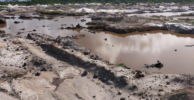 Grootschalige zandafgravingen nabij landingsbaan internationale luchthaven Zanderij